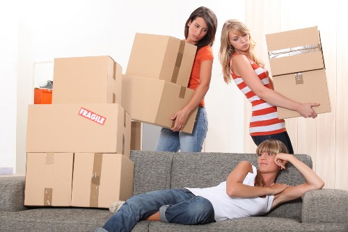 Professional movers carrying furniture through a flat building in The Hyde